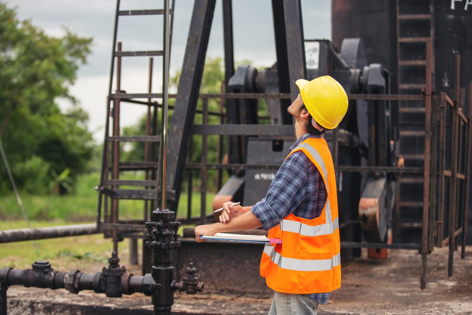 workers-standing-checking-beside-working-oil-pumps-scaled.jpg